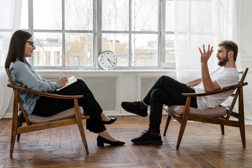 pexels-photo-4101143-4101143 A therapist engaging in a counseling session with a male patient to support mental health.